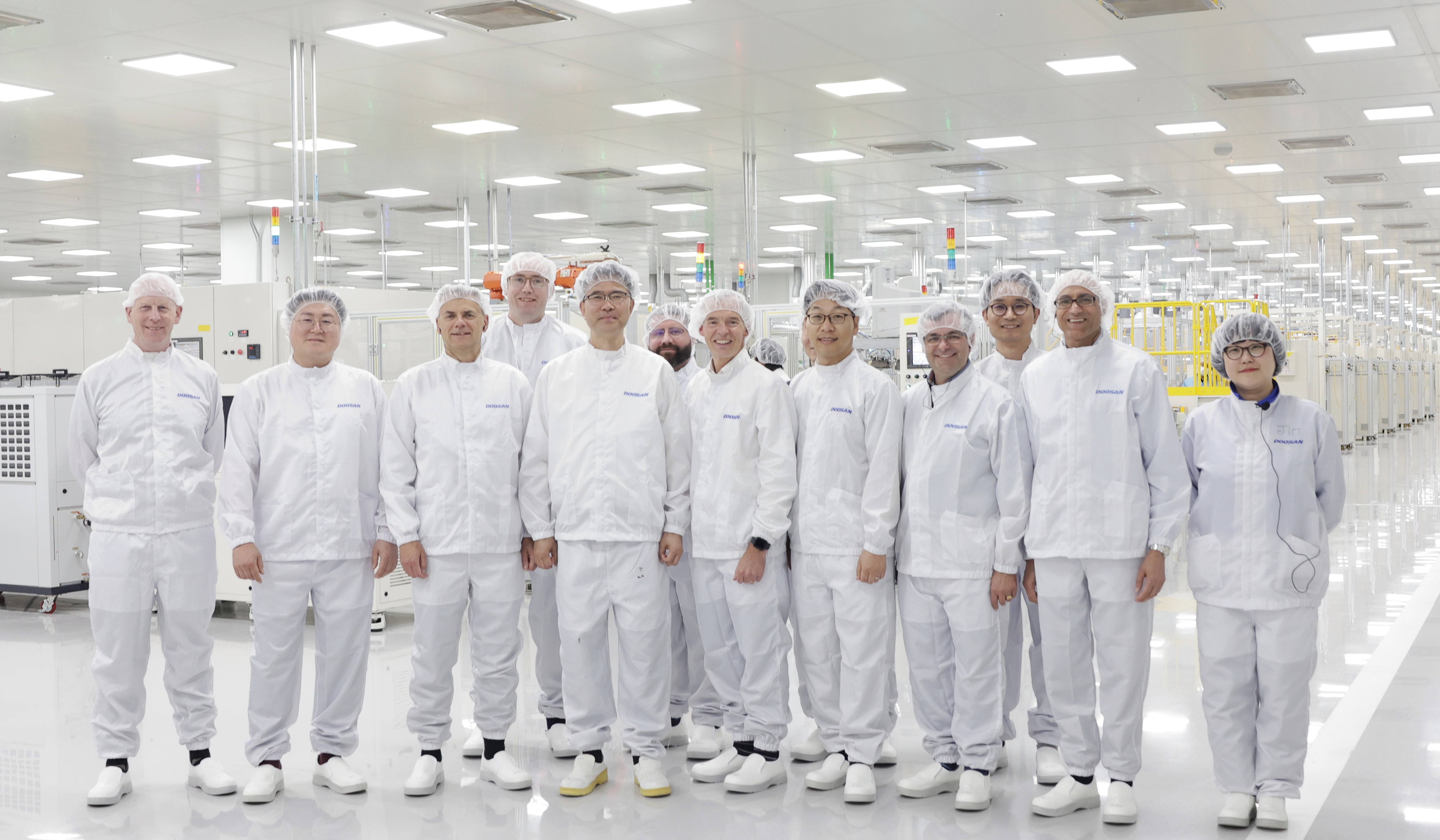 The Ceres and Doosan teams in white PPE inside the Doosan factory